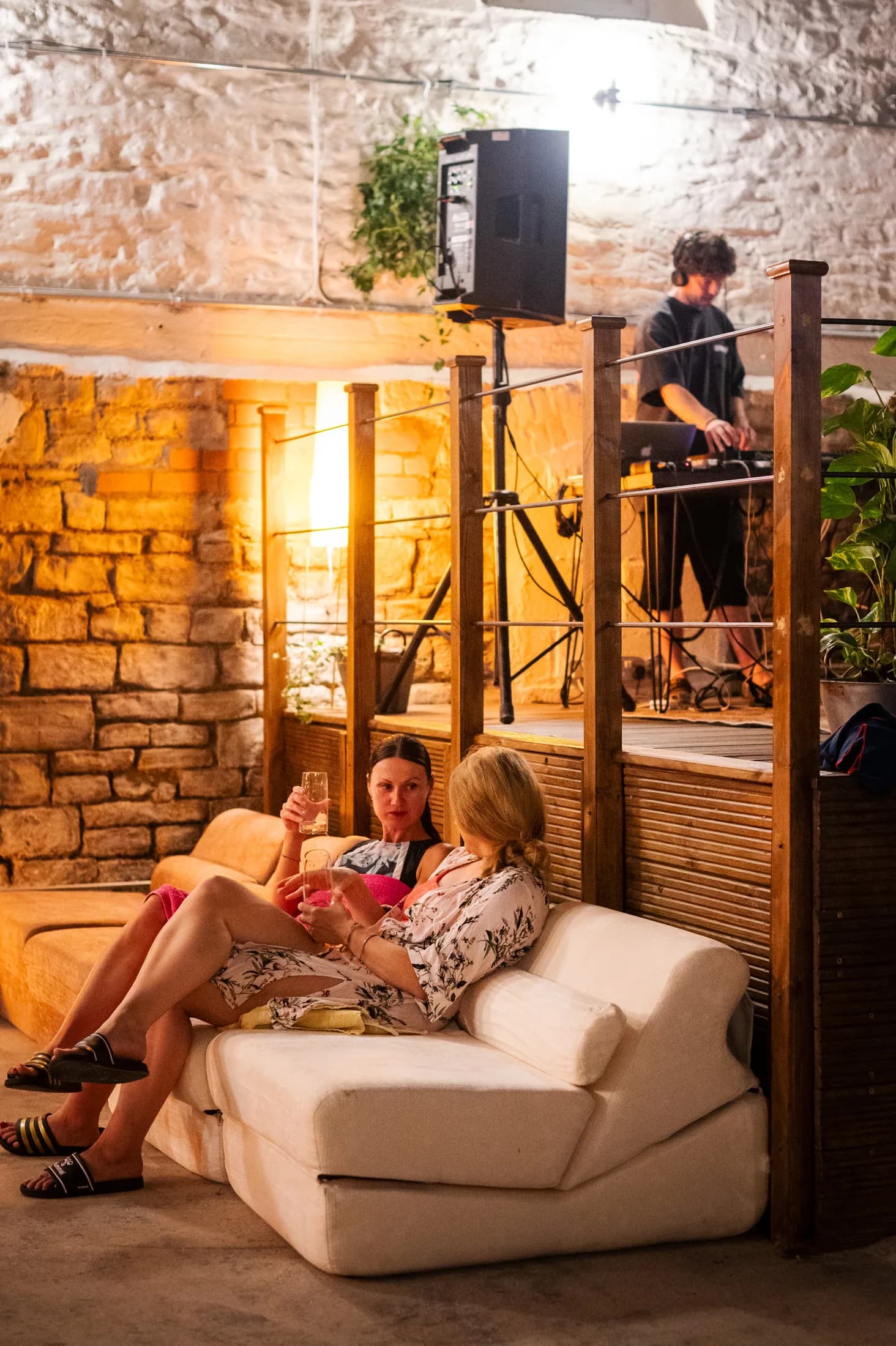 Guests chatting on a sofa beside the DJ booth